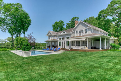 Inspiration for a large timeless two-story wood and shingle house exterior remodel in New York with a shingle roof