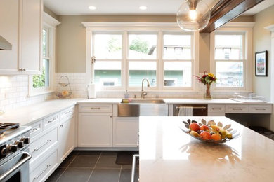 Inspiration for a timeless eat-in kitchen remodel in Minneapolis with a farmhouse sink, shaker cabinets, white cabinets, quartzite countertops, ceramic backsplash, stainless steel appliances and an island