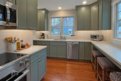 Enclosed kitchen - mid-sized traditional medium tone wood floor enclosed kitchen idea in Philadelphia with an undermount sink, shaker cabinets, green cabinets, quartz countertops, beige backsplash, subway tile backsplash, stainless steel appliances, no island and beige countertops