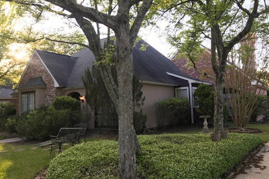 Mid-sized traditional brown two-story concrete exterior home idea in New Orleans with a mixed material roof