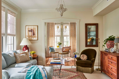 Modelo de salón cerrado clásico con paredes beige, suelo de madera en tonos medios y suelo marrón