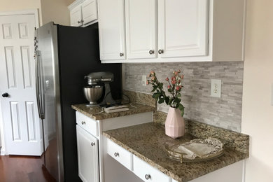 Example of a mid-sized classic medium tone wood floor and brown floor open concept kitchen design in Atlanta with a double-bowl sink, raised-panel cabinets, white cabinets, granite countertops, gray backsplash, marble backsplash, stainless steel appliances, an island and beige countertops