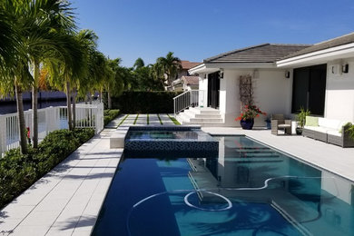 Design ideas for a mid-sized modern backyard rectangular pool in Miami with concrete pavers.