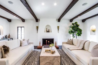 Photo of a large mediterranean formal open plan living room in Los Angeles with white walls, dark hardwood flooring, a standard fireplace, no tv and brown floors.