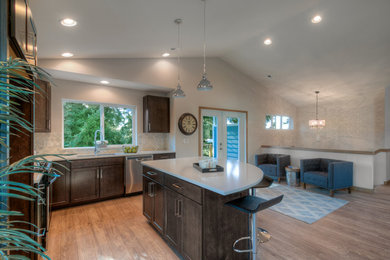 Eat-in kitchen - mid-sized transitional l-shaped light wood floor eat-in kitchen idea in Seattle with a farmhouse sink, recessed-panel cabinets, dark wood cabinets, quartz countertops, multicolored backsplash, mosaic tile backsplash, stainless steel appliances and an island