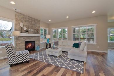Inspiration for a large contemporary open concept medium tone wood floor living room remodel in Seattle with a standard fireplace and a stone fireplace