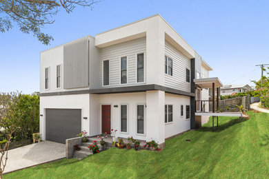 Photo of a large modern two-storey white house exterior in Brisbane with concrete fiberboard siding, a flat roof, a metal roof and board and batten siding.