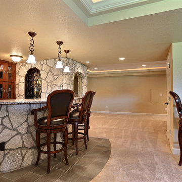 Open Basement Concept in Centennial, CO with tray ceilings and stacked stone