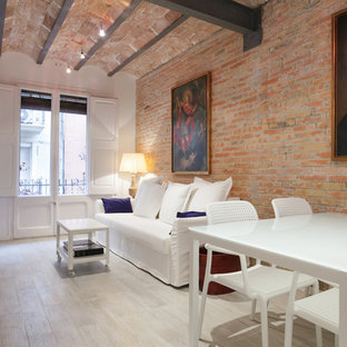 Modelo de salón para visitas abierto, mediterráneo, de tamaño medio, con paredes blancas, suelo de madera pintada y pared multimedia