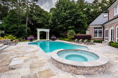 Large elegant backyard stone and custom-shaped pool photo in Atlanta