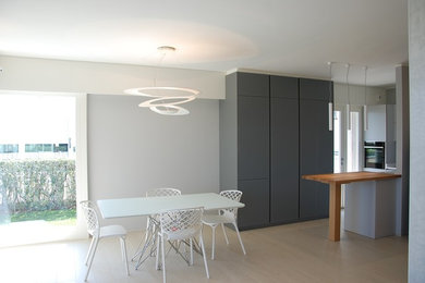 Immagine di un soggiorno design di medie dimensioni e aperto con pareti grigie, pavimento con piastrelle in ceramica, TV a parete e pavimento bianco
