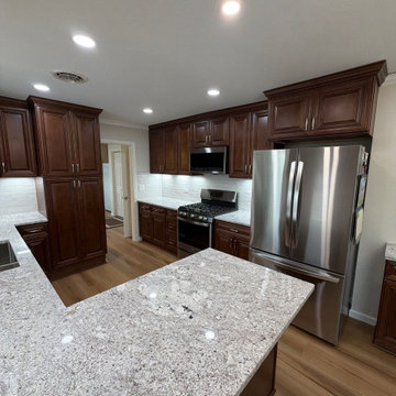 USCD cabinetry accompanied granite countertops, porcelain tile backsplash and Ca