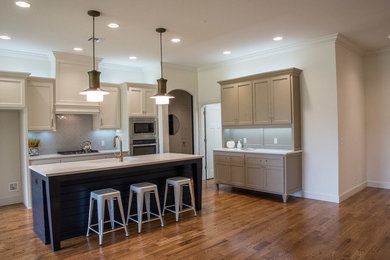 Inspiration for a mid-sized transitional medium tone wood floor and brown floor eat-in kitchen remodel in Oklahoma City with flat-panel cabinets, white cabinets, quartz countertops, an island, a single-bowl sink, gray backsplash, ceramic backsplash and stainless steel appliances