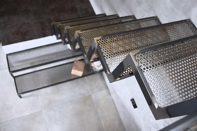 Aménagement d'un escalier courbe industriel de taille moyenne avec des marches en métal.