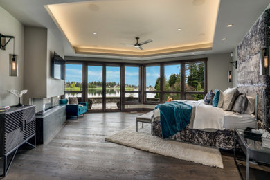 Example of a huge mountain style master dark wood floor, black floor and coffered ceiling bedroom design in Seattle with gray walls, a ribbon fireplace and a metal fireplace