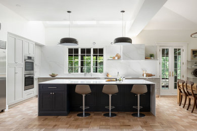 Example of a large transitional light wood floor eat-in kitchen design in Boston with an undermount sink, recessed-panel cabinets, gray cabinets, quartz countertops, white backsplash, quartz backsplash, stainless steel appliances, an island and white countertops