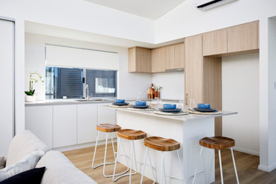 Kitchen - modern l-shaped laminate floor and brown floor kitchen idea in Perth with an undermount sink, quartz countertops, white backsplash, porcelain backsplash, stainless steel appliances, an island and white countertops