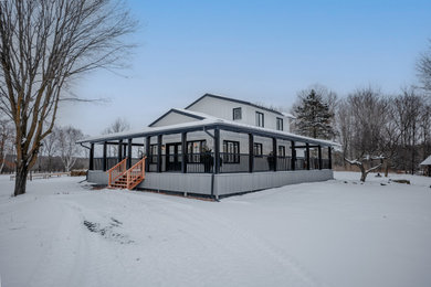 Modelo de fachada de casa blanca y negra de estilo de casa de campo de dos plantas con revestimientos combinados, tejado a dos aguas, tejado de metal y panel y listón