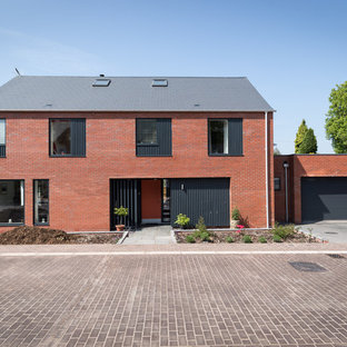 Photo of a medium sized and red modern brick detached house in West Midlands with three or more floors and a pitched roof.