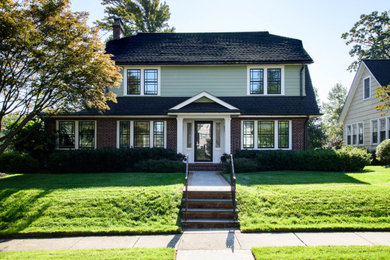 Inspiration for a large timeless green three-story mixed siding and board and batten house exterior remodel in New York with a shingle roof and a black roof
