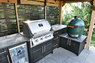 Inspiration for a small modern side yard concrete paver patio kitchen remodel in Milwaukee with a pergola