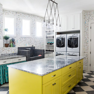 Medium sized bohemian u-shaped utility room in Salt Lake City with an utility sink, shaker cabinets, yellow cabinets, quartz worktops, multi-coloured walls, porcelain flooring and a stacked washer and dryer.