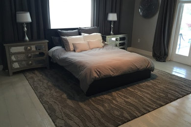 Photo of a large modern master bedroom in Orlando with grey walls, painted wood floors, no fireplace and beige floor.