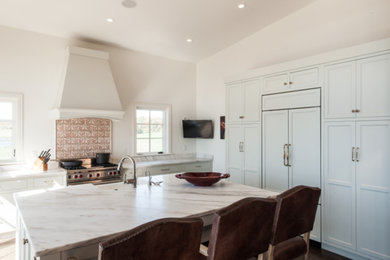 Kitchen - mid-sized transitional l-shaped dark wood floor and brown floor kitchen idea in St Louis with a farmhouse sink, recessed-panel cabinets, white cabinets, quartzite countertops, paneled appliances, an island and white countertops