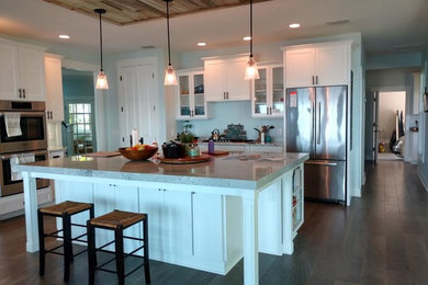 Kitchen - mid-sized transitional medium tone wood floor and brown floor kitchen idea in Orlando with shaker cabinets, white cabinets, quartzite countertops and an island