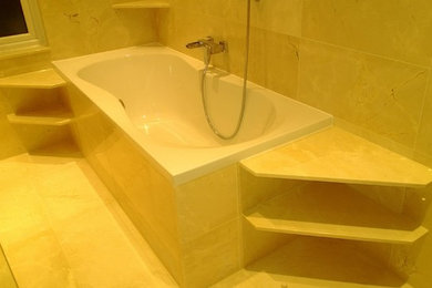 Foto de cuarto de baño principal moderno de tamaño medio con encimera de mármol, baldosas y/o azulejos beige, baldosas y/o azulejos de piedra, bañera esquinera, ducha esquinera y suelo de mármol