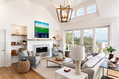 Diseño de sala de estar abierta costera grande con paredes blancas y suelo de madera clara