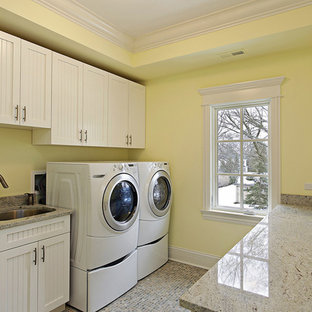 Photo of a medium sized classic galley separated utility room in San Diego with a submerged sink, shaker cabinets, white cabinets, engineered stone countertops, yellow walls, ceramic flooring, a side by side washer and dryer and multi-coloured floors.