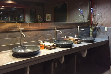 Mid-sized asian master gray tile and stone tile slate floor and gray floor bathroom photo in Other with open cabinets, brown walls, a vessel sink and concrete countertops