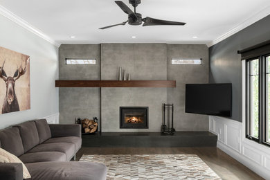 Trendy open concept dark wood floor and brown floor family room photo in Philadelphia with gray walls, a standard fireplace and a wall-mounted tv