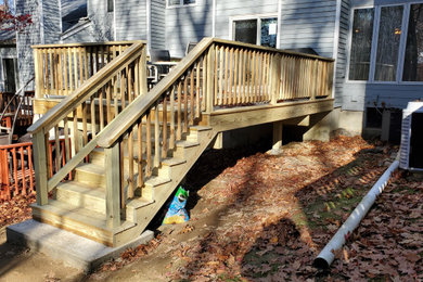 Example of a mid-sized classic backyard ground level wood railing deck design in New York
