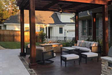 Example of a mid-sized classic backyard concrete patio design in Other with a fire pit and a pergola