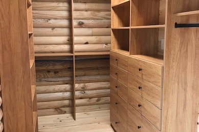 Foto de armario vestidor unisex de tamaño medio con armarios con paneles lisos, puertas de armario de madera clara, suelo de madera clara y suelo marrón