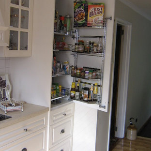 Mittelgroße Moderne Küche mit Doppelwaschbecken, profilierten Schrankfronten, weißen Schränken, Glas-Arbeitsplatte, Küchenrückwand in Weiß, Rückwand aus Keramikfliesen, Küchengeräten aus Edelstahl, Porzellan-Bodenfliesen und Vorratsschrank in Melbourne