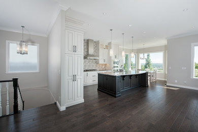 Design ideas for a large transitional l-shaped open plan kitchen in Calgary with an undermount sink, raised-panel cabinets, white cabinets, granite benchtops, multi-coloured splashback, matchstick tile splashback, stainless steel appliances, dark hardwood floors and with island.
