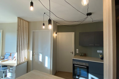 Idée de décoration pour une petite salle à manger ouverte sur la cuisine avec un mur vert, sol en stratifié, aucune cheminée, un sol beige et éclairage.