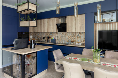 Источник вдохновения для домашнего уюта: большая угловая кухня в современном стиле с обеденным столом, плоскими фасадами, синими фасадами, черной техникой, островом и коричневой столешницей