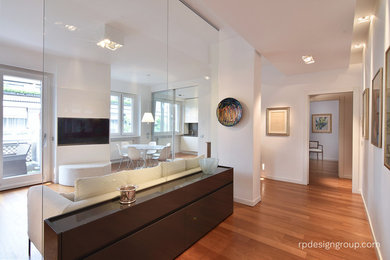 Foto di un soggiorno contemporaneo di medie dimensioni con pareti bianche, pavimento in legno massello medio e TV a parete