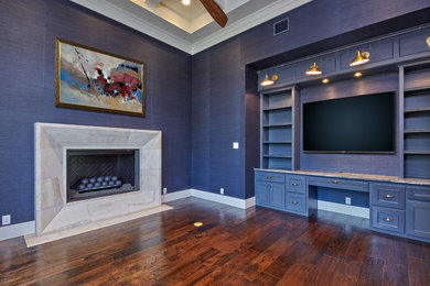 Transitional study room in Austin with blue walls, medium hardwood floors and a stone fireplace surround.