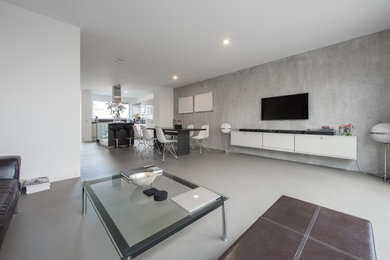 This is an example of an expansive industrial formal open concept living room in Cologne with concrete floors, grey floor and grey walls.
