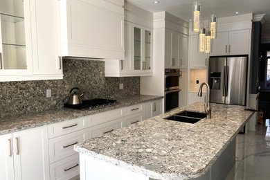 Inspiration for a large transitional l-shaped eat-in kitchen remodel in Toronto with flat-panel cabinets, white cabinets and an island