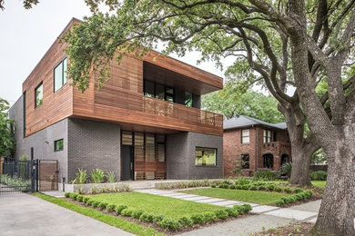Design ideas for a large contemporary two-storey black exterior in Houston with mixed siding and a flat roof.