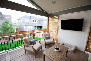 Inspiration for a mid-sized transitional backyard privacy deck remodel in Denver with a roof extension