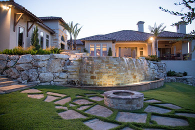 This is an example of a large traditional backyard stone retaining wall landscape in Other.