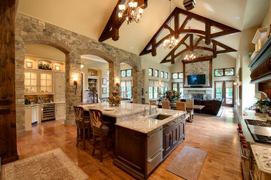 Huge elegant l-shaped light wood floor enclosed kitchen photo in Indianapolis with an undermount sink, recessed-panel cabinets, dark wood cabinets, granite countertops, stainless steel appliances and an island