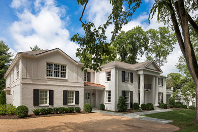 Inspiration for a large timeless white two-story stone house exterior remodel in Nashville with a hip roof and a shingle roof